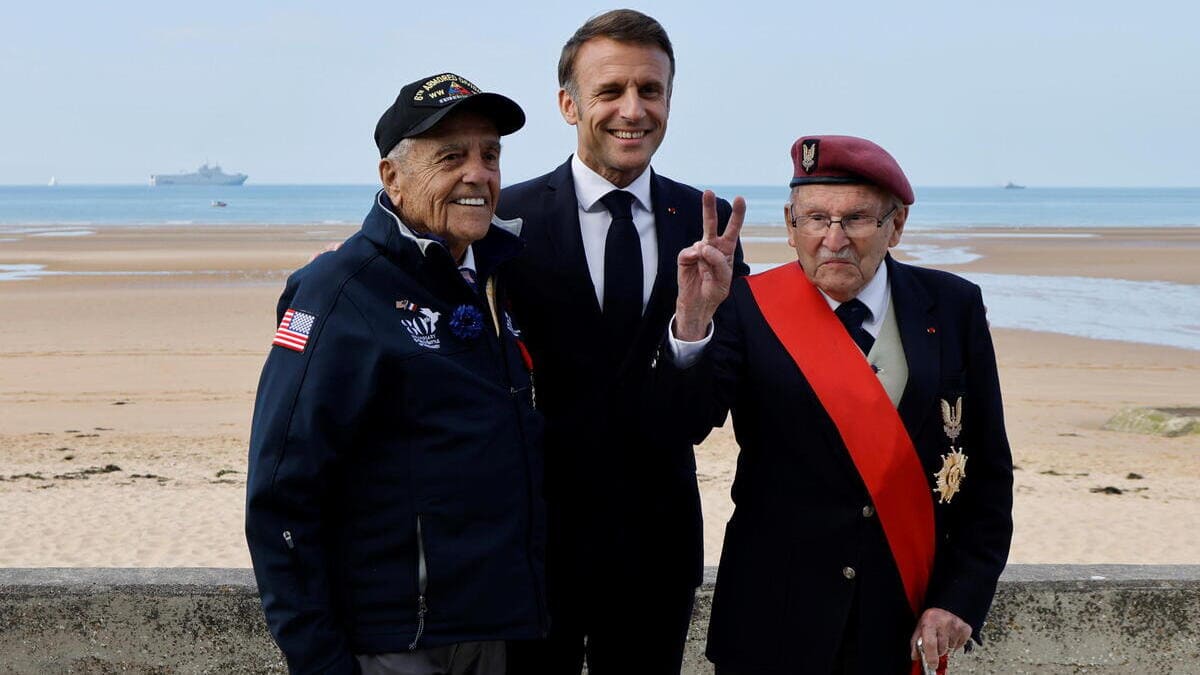 Emmanuel Macron con due veterani della seconda guerra mondiale durante le celebrazioni per l'80mo anniversario del D-Day