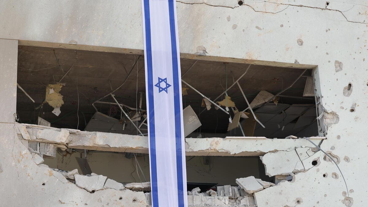 Una bandiera di Israele sventola su una scuola colpita da un missile balistico iraniano