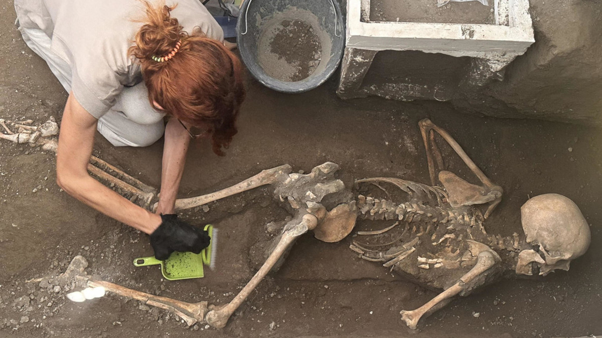 Un’archeologa al lavoro sui resti recentemente scoperti di una vittima dell’eruzione del Vesuvio che distrusse Pompei nel 79 d.C. (foto Ansa)