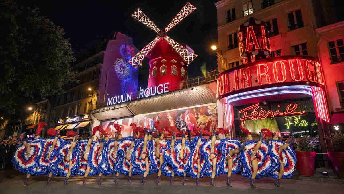 Ballerine impegnate in uno spettacolo di fronte al Moulin Rouge di Parigi, 6 maggio 2024 (foto Ansa)