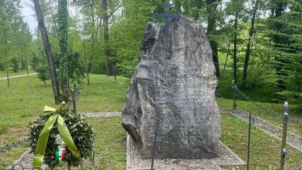 La lapide in memoria dei caduti dell'eccidio di Porzûs nei pressi dell'ingresso principale del Bosco Romagno (foto di Giuseppe Beltrame)