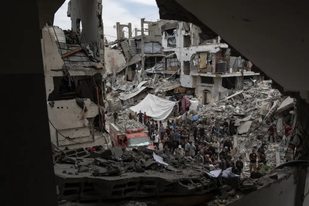Palestinesi tra i resti di un edificio bombardato dall’Idf a Jabalia, nel Nord della Striscia di Gaza, 15 maggio 2025 (foto Ansa)