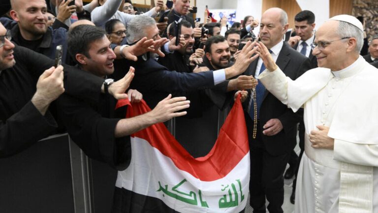 Papa Leone XIV saluta un gruppo di fedeli che sventolano la bandiera dell'Iraq
