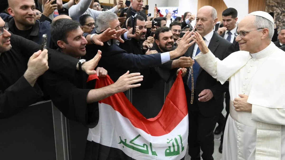 Papa Leone XIV saluta un gruppo di fedeli che sventolano la bandiera dell'Iraq