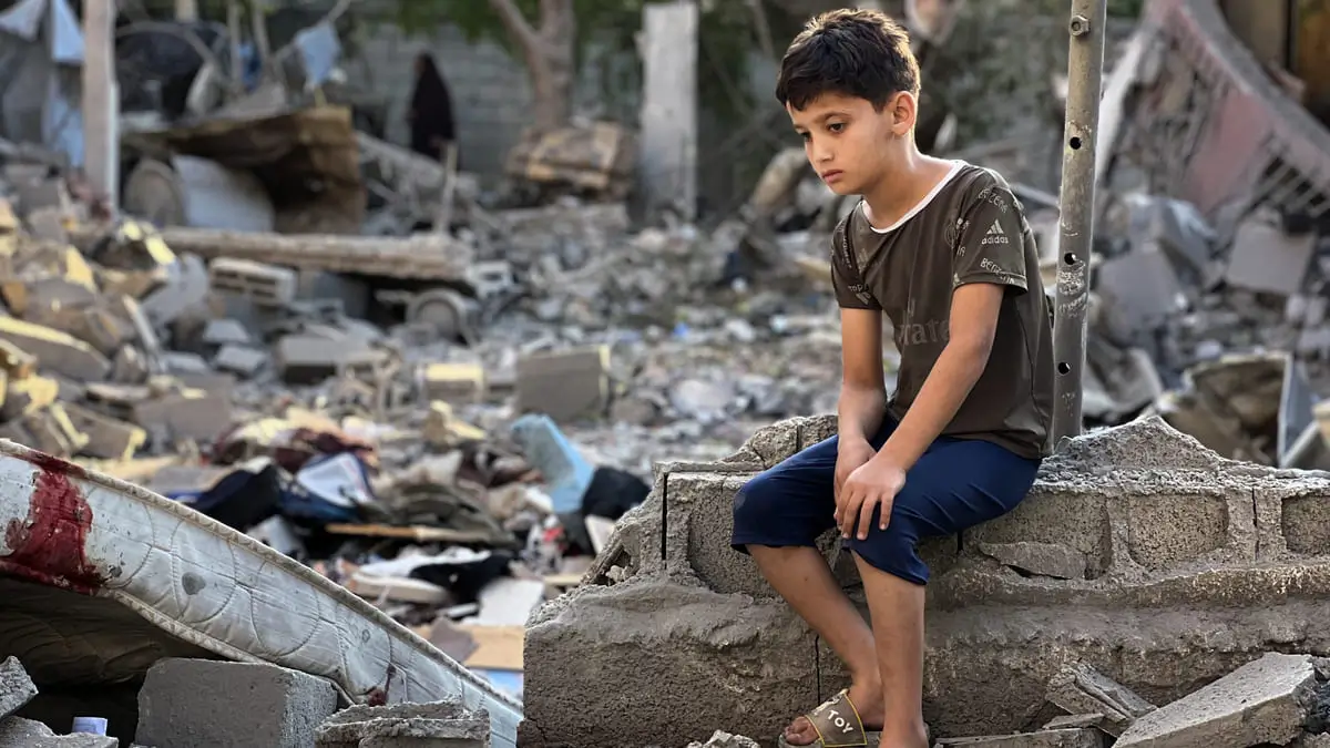 Un bambino palestinese nei pressi del campo profughi di Nusairat, Gaza, 24 giugno 2025 (foto Ansa)