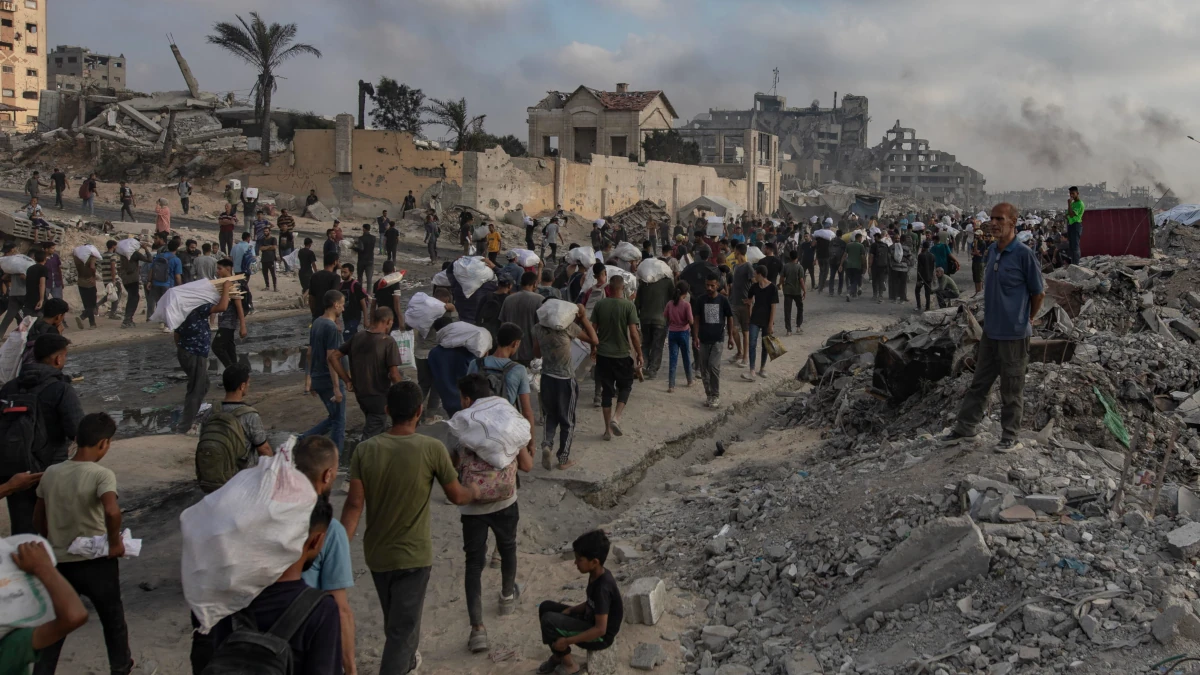 Sfollati palestinesi di ritorno da un centro di distribuzione di aiuti umanitari lungo Rashid Street, Jabalia, 22 giugno 2025 (foto Ansa)