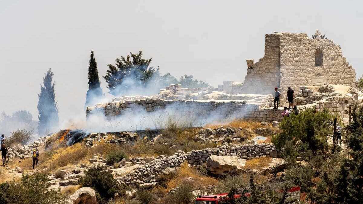 Gli abitanti di Taybeh, in Cisgiordania, cercano di spegnere il fuoco appiccato dai coloni israeliani di fianco ai resti dell'antica chiesa di San Giorgio del V secolo