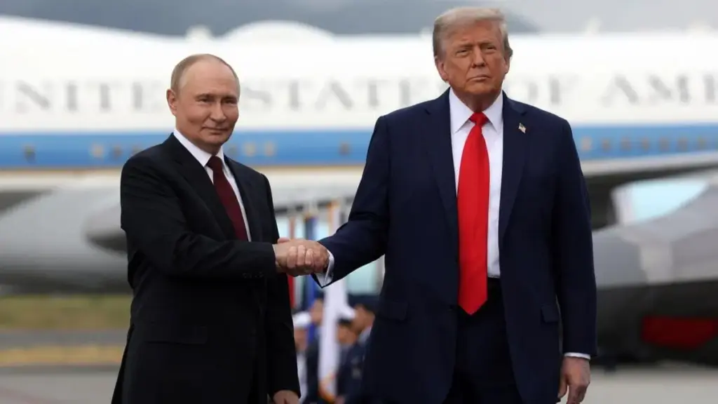Donald Trump e Vladimir Putin si stringono la mano all'arrivo ad Anchorage, in Alaska, per il vertice sull'Ucraina