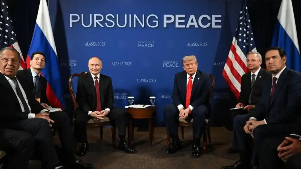 Le delegazioni di Stati Uniti e Russia "alla ricerca della pace", come recita la scritta sullo sfondo, prima dell'inizio dei colloqui in Alaska