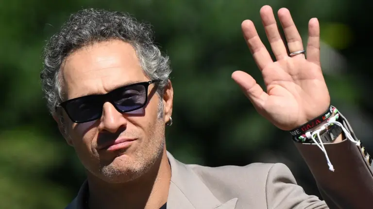 L’attore italiano Claudio Santamaria appena sbarcato al Lido di Venezia per la Mostra del Cinema saluta giornalisti e fan esibendo un braccialetto pro Palestina, 6 settembre 2025 (foto Ansa)