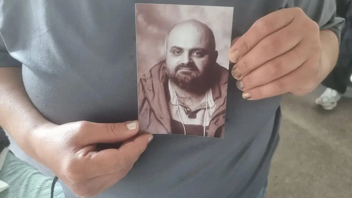Una donna mostra la foto di Ashur Sarnaya, ucciso il 10 settembre sotto casa sua da un terrorista islamico