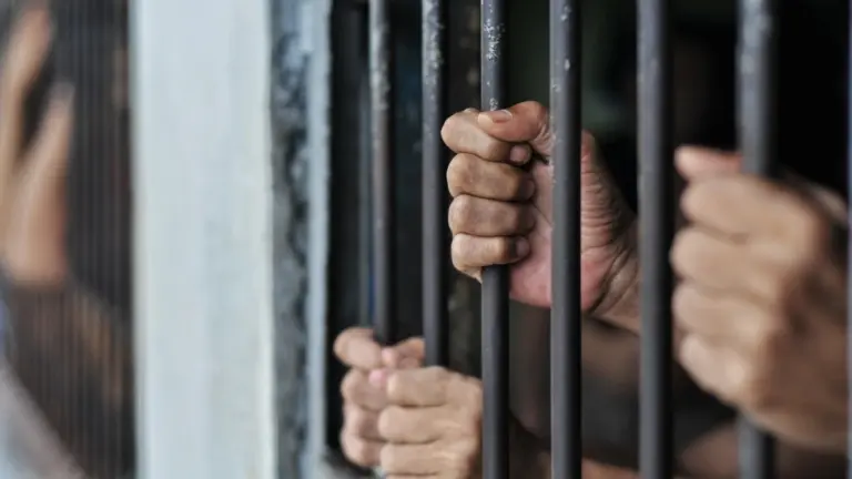 Mani di detenuti tra le sbarre di un carcere