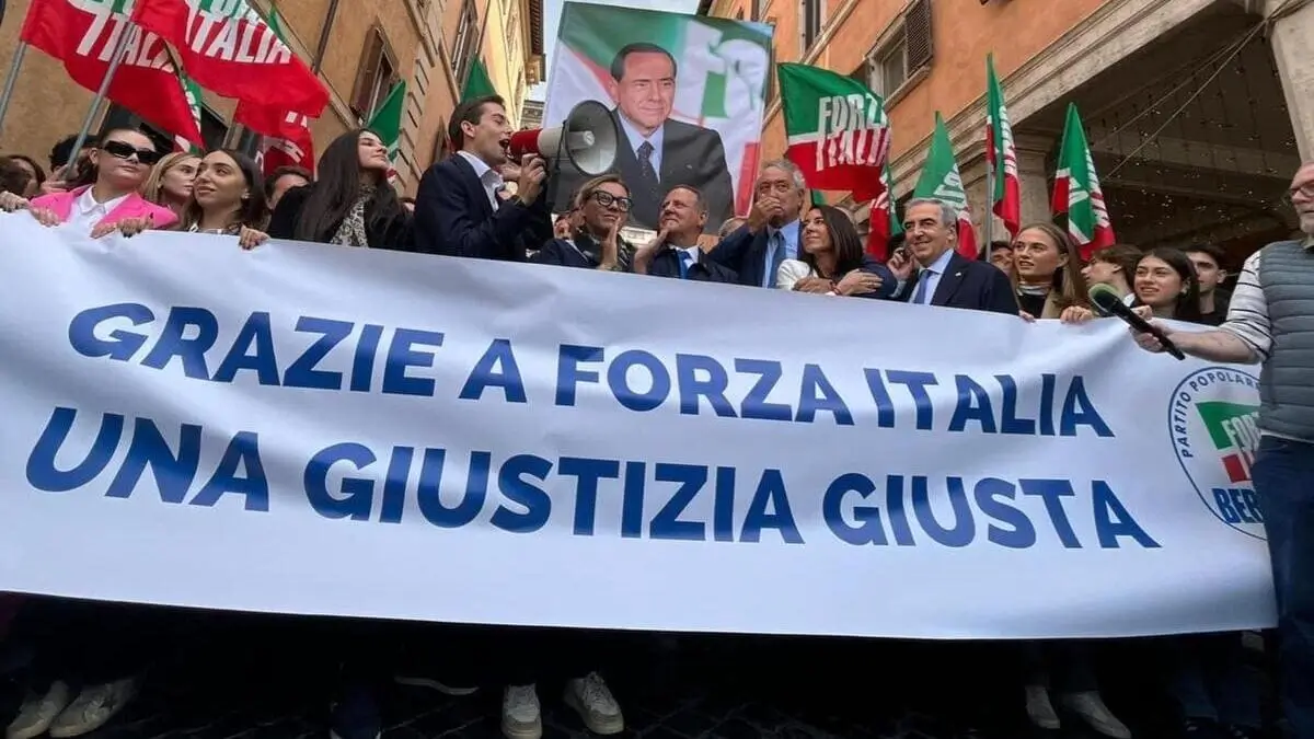 Una gigantografia di Silvio Berlusconi e attorno le bandiere di Forza Italia, durante il flash mob di Forza Italia per celebrare l'approvazione definitiva della riforma sulla separazione delle carriere dei magistrati, subito dopo il voto al Senato, in piazza Navona, Roma, 30 ottobre 2025 (ansa)