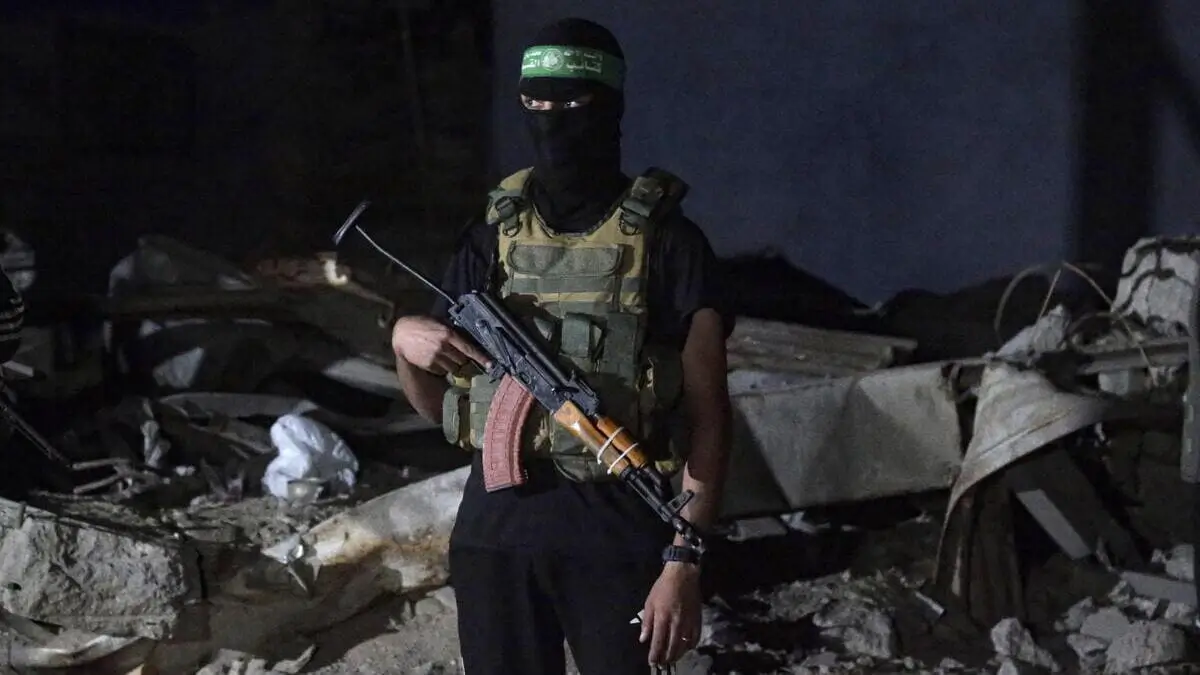 Un soldato di Hamas supervisiona la consegna di alcune salme di ostaggi israeliani deceduti alla Croce Rossa a Gaza