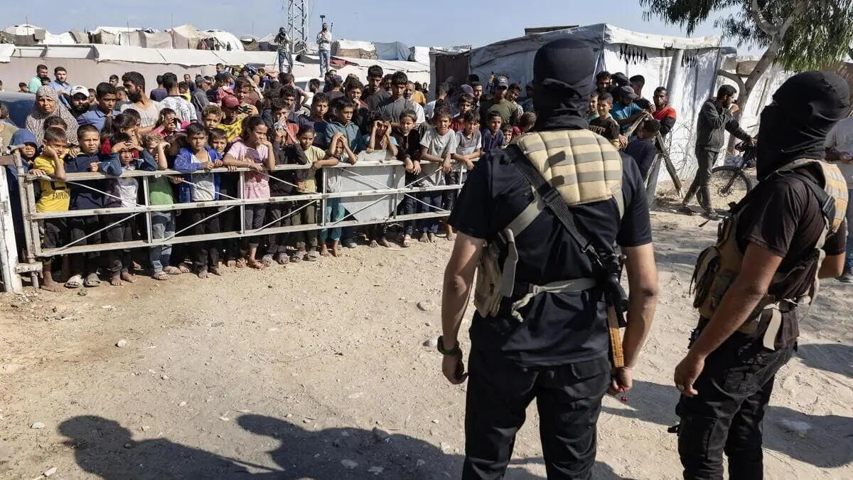 Due combattenti delle Brigate Al-Qassam di Hamas sorvegliano la consegna degli ostaggi al Comitato Internazionale della Croce Rossa a sud di Deir al-Balah, nella Striscia di Gaza
