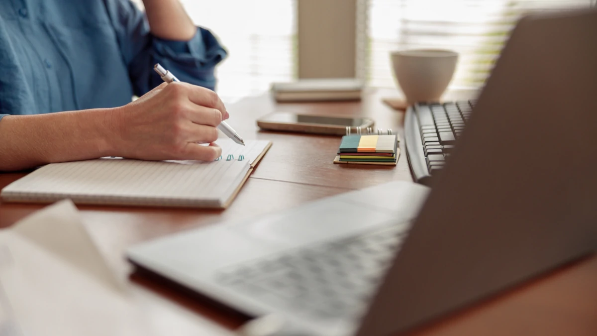 Donna al lavoro seduta a una scrivania davanti al pc