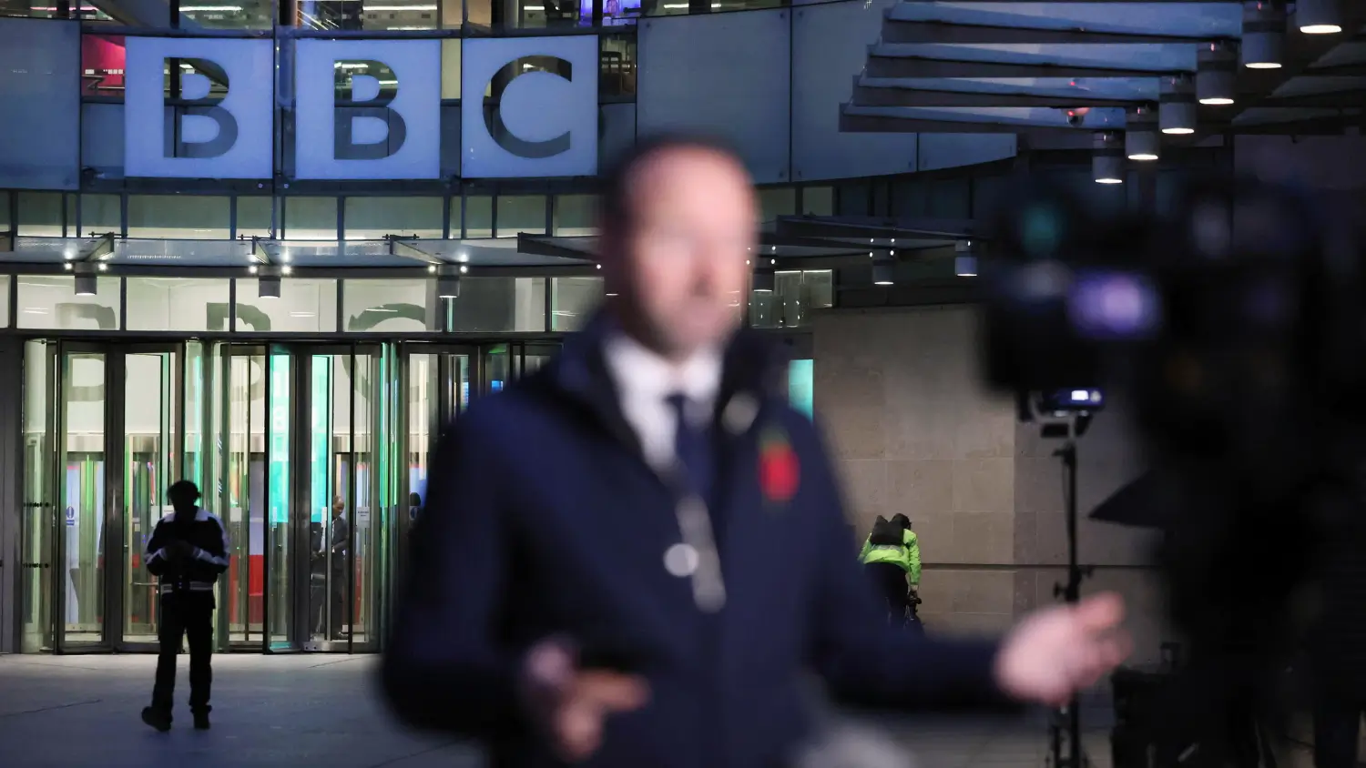 Un inviato tv parla alla telecamera davanti alla sede della BBC, a Londra