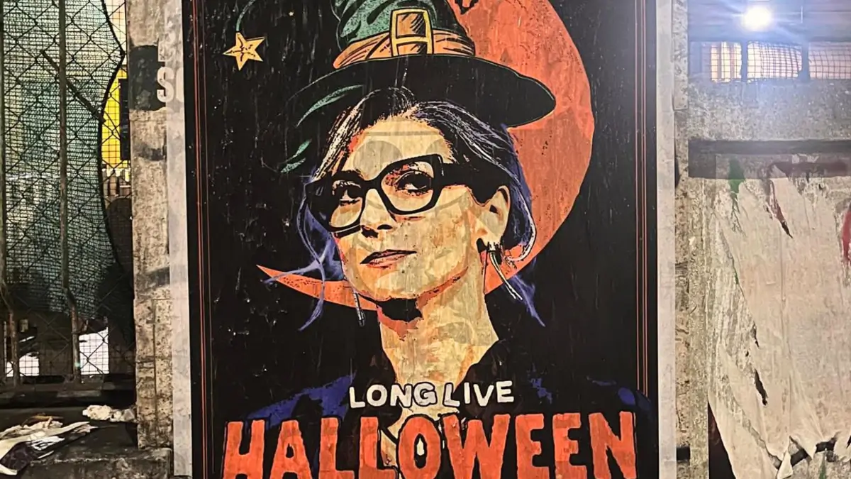 Poster artistico di Francesca Albanese, ritratta con grandi occhiali e un cappello da strega verde appuntito. Sullo sfondo c'è una luna arancione. Il testo in primo piano recita: 'LONG LIVE HALLOWEEN' in caratteri rossi e bianchi