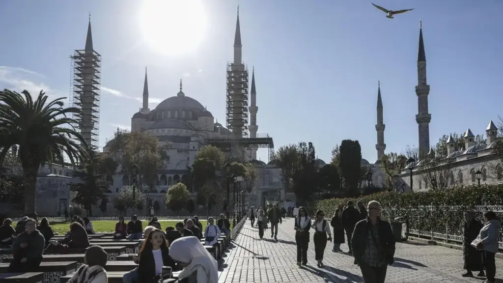 La gente passeggia in Turchia davanti alla Moschea blu di Istanbul, che sarà visitata da Leone XIV