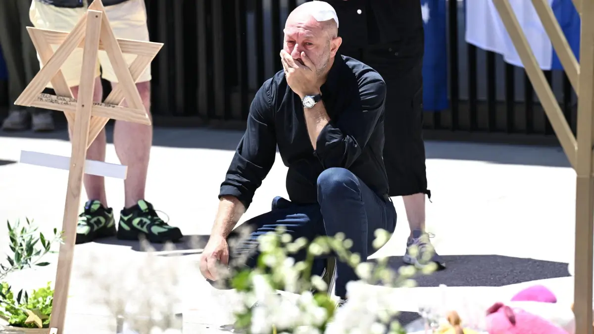 Arsen Ostrovsky, sopravvissuto all'attentato di Bondi Beach, si commuove di fronte ai fiori lasciati in ricordo delle vittime (foto Ansa)
