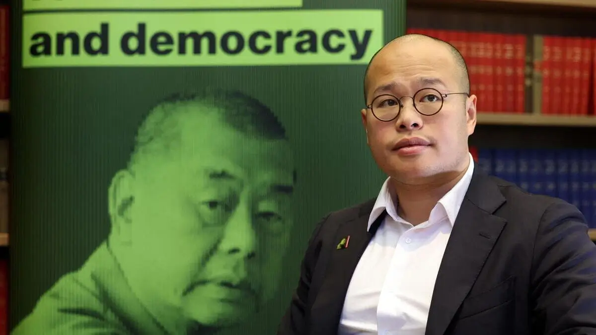 Sebastien Lai, con una foto del padre alle spalle, presenta il processo farsa di Jimmy Lai in una conferenza stampa a Londra