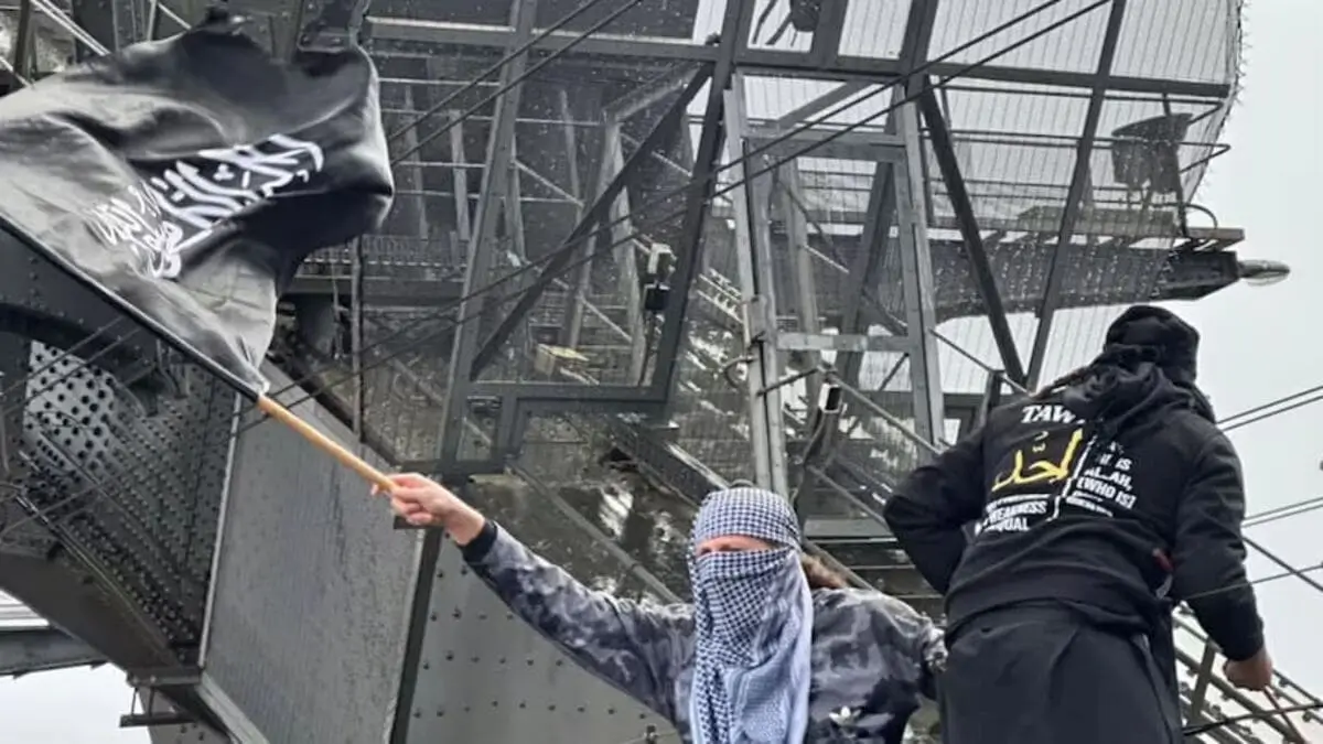 Youssef Uweinat, condannato a quattro anni di carcere per terrorismo, sventola una bandiera simile a quelle dell'Isis durante una manifestazione ProPal a Sydney