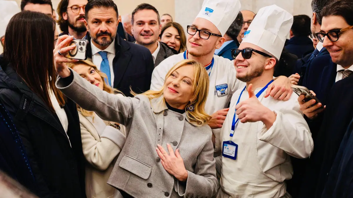 La premier Giorgia Meloni scatta un selfie con due dipendenti di Palazzo Chigi durante la cerimonia degli auguri natalizi nel cortile d'onore di Palazzo Chigi, Roma 23 dicembre 2025 governo