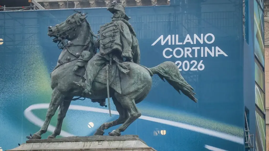 La statua equestre di Vittorio Emanuele II in piazza Duomo, a Milano. Sullo sfondo la scritta che ricorda le Olimpiadi invernali "Milano Cortina 2026"