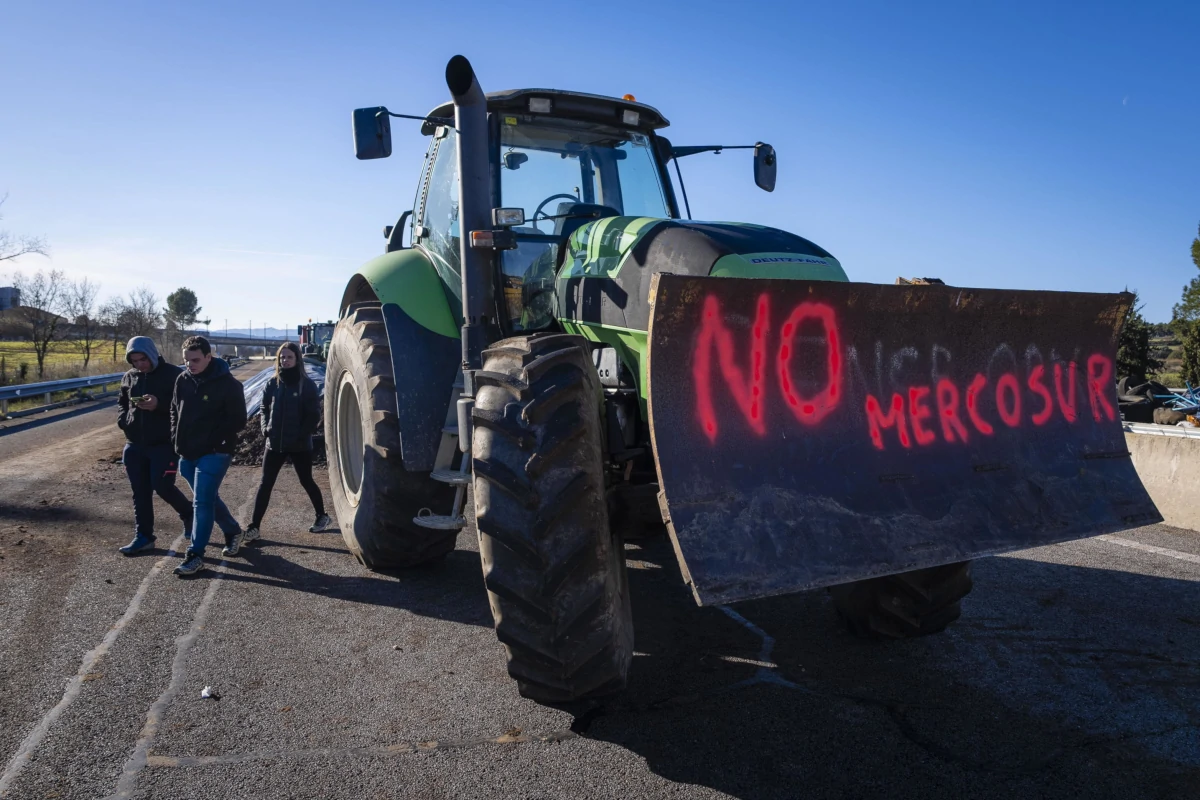 Agricoltori in protesta con i trattori in autostrada a Pontos, provincia di Girona, Spagna, contro l’accordo di libero scambio tra Unione Europea e Mercosur, 11 gennaio 2026 (foto Ansa)