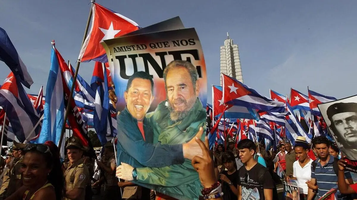 Un cartello raffigurante Hugo Chávez e Fidel Castro viene sollevato a L’Avana durante una manifestazione (foto Ansa)