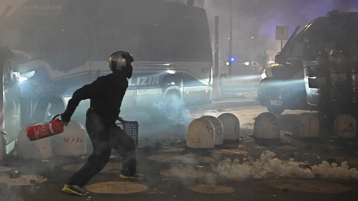 Un manifestante alla manifestazione pro Askatasuna lancia un idrante contro la polizia