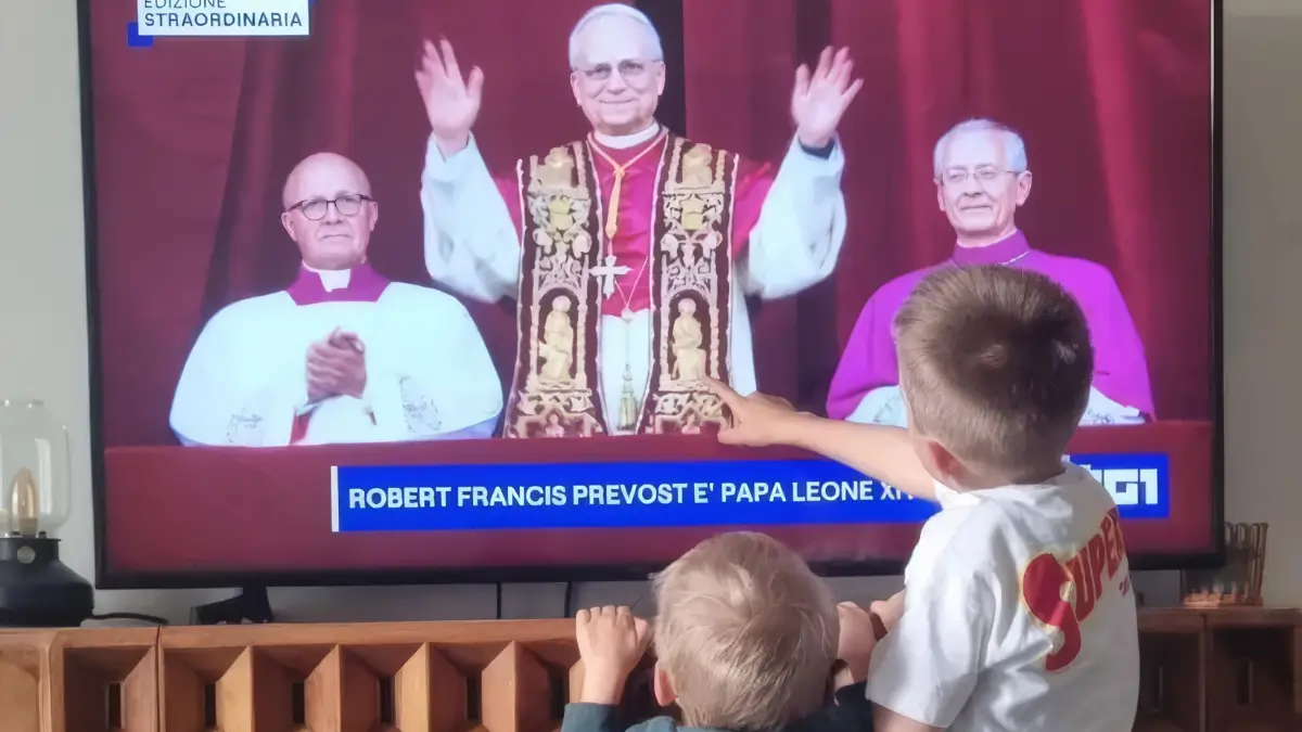 Due bambini guardano in tv la prima apparizione di Robert Prevost come papa Leone XIV
