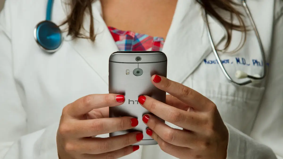 Una dottoressa consulta il proprio smartphone