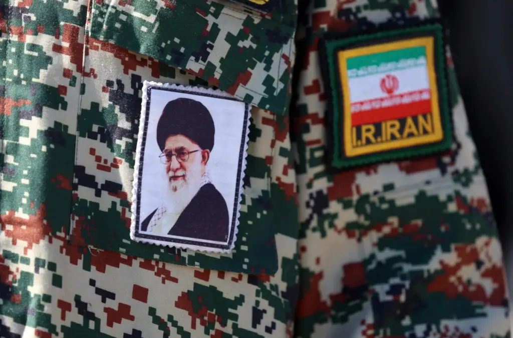 Un’immagine della guida suprema Ali Khamenei sulla divisa di un militare iraniano, Teheran, 27 febbraio 2026 (foto Ansa)