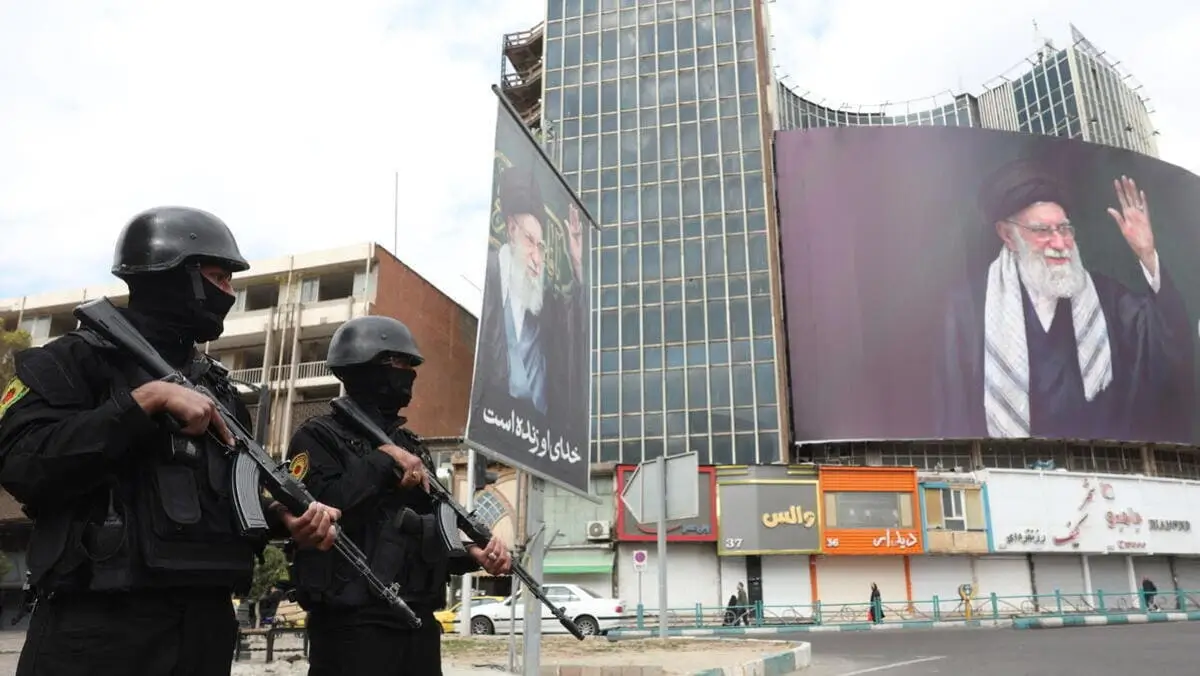 Le forze di sicurezza iraniane montano la guardia di fianco al cartellone pubblicitario della Guida Suprema iraniana, l'Ayatollah Ali Khamenei, in piazza Valiasr a Teheran. L'ayatollah è stato ucciso sabato in un raid militare di Usa e Israele