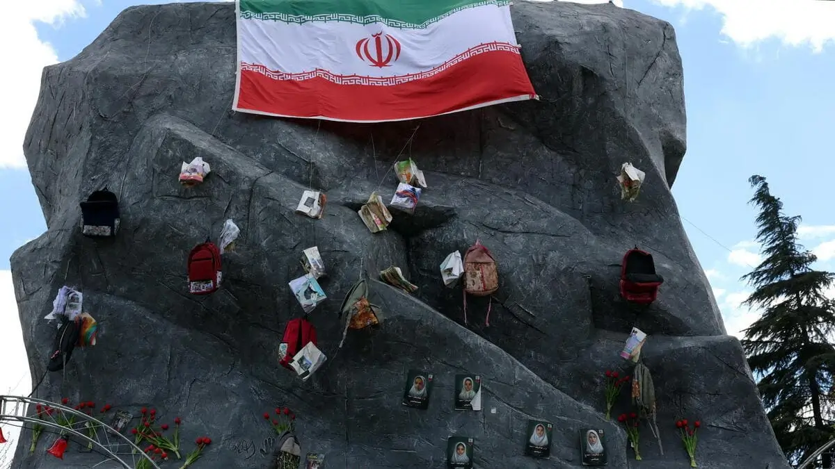Una bandiera iraniana sventola su una statua a Teheran per omaggiare le studentesse uccise nell'attacco Usa alla scuola di Minab