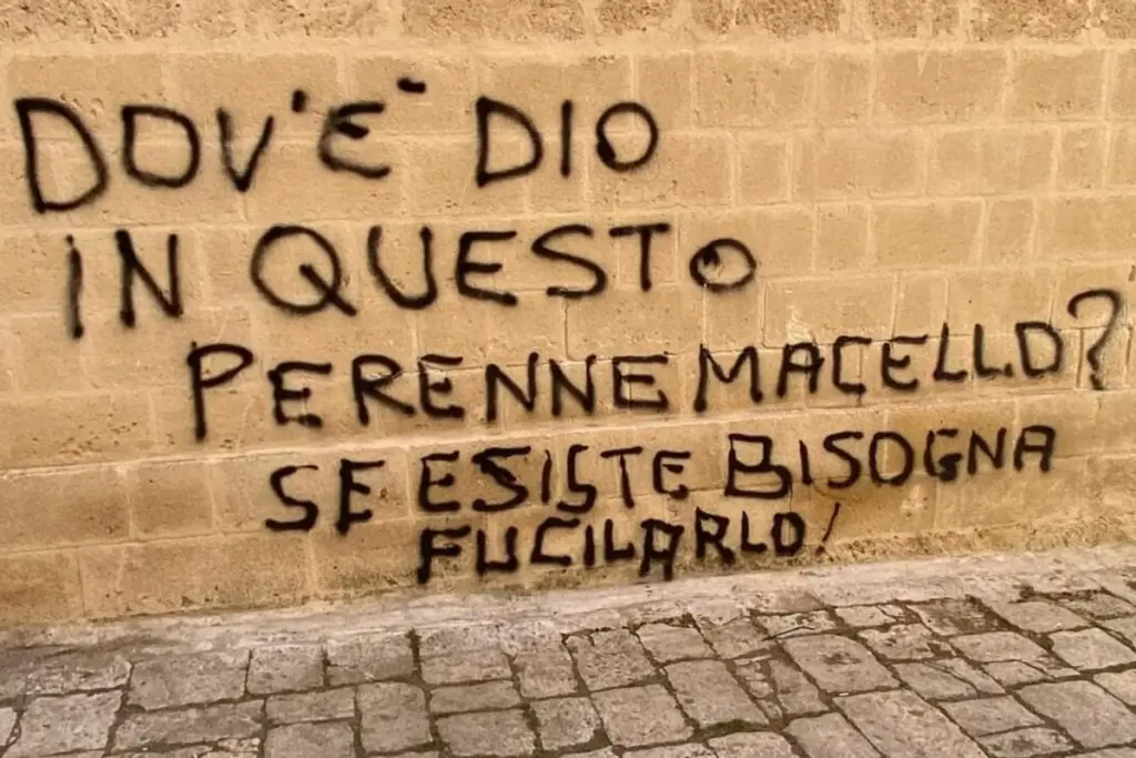 La scritta blasfema comparsa su un muro della chiesa madre di San Donaci, in provincia di Brindisi