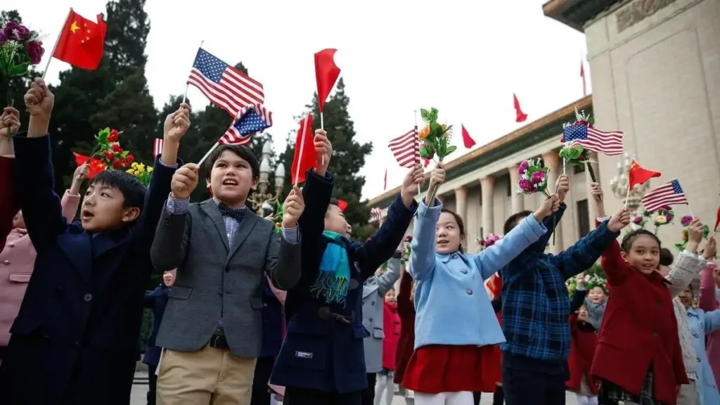 Bambini sventolano bandiere americane e cinesi in Piazza Tiananmen in attesa dell'arrivo di Donald Trump e Xi Jinping nel 2017