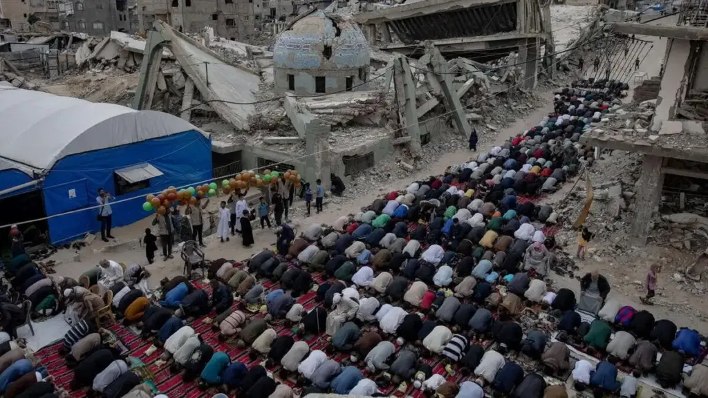 Palestinesi musulmani pregano davanti alle rovine di una moschea a Khan Younis, nella Striscia di Gaza devastata dalla guerra
