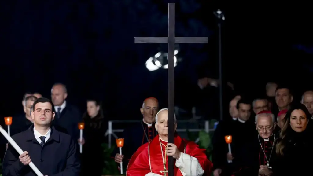 Leone XIV porta la croce durante la Via Crucis del Venerdì Santo al Colosseo