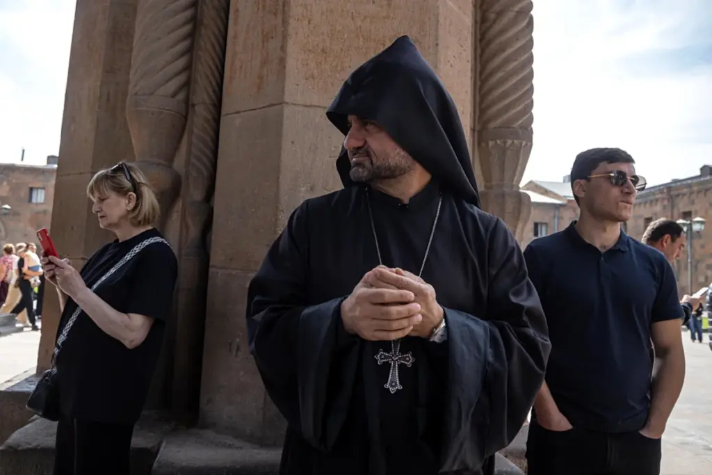 Un prete davanti alla cattedrale di Echmiadzin, una delle pi&ugrave; antiche del mondo, centro della spiritualit&agrave; dei cristiani armeni, 19 ottobre 2025 (foto Ansa)