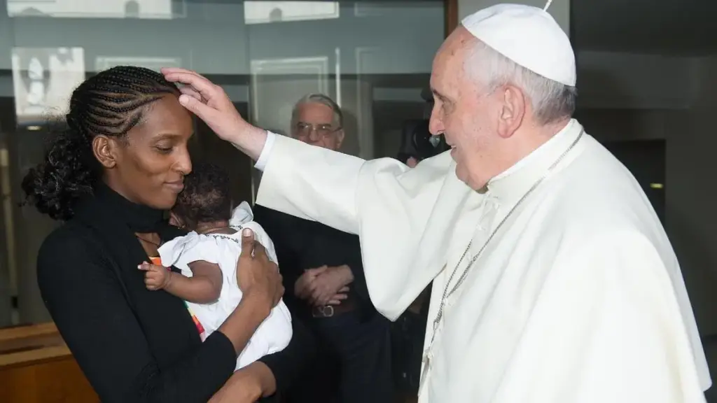 Mariam Ibraheem tiene in braccio la figlia Maya mentre viene accolta in Vaticano da papa Francesco