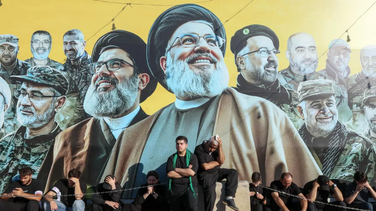 Musulmani sciiti ascoltano la storia dell'Imam Hussain durante una processione per l'Ashura, davanti alle immagini dei defunti leader di Hezbollah, nella zona sud di Beirut, in Libano, il 26 giugno 2026.