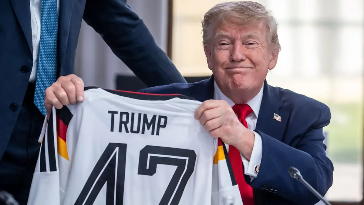 Il cancelliere Merz consegna al presidente degli Stati Uniti Donald Trump una maglia della nazionale di calcio tedesca con il numero 47 al G7