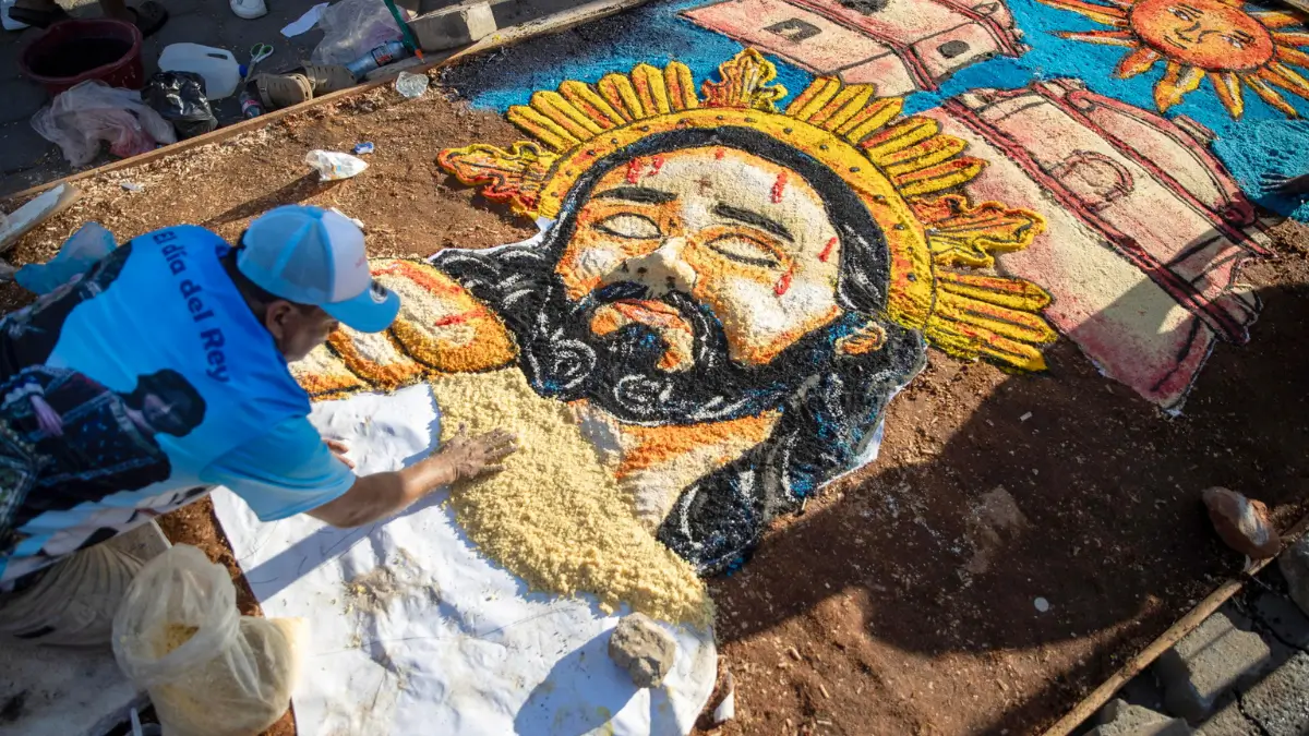 Un uomo aggiunge dettagli a un tappeto di segatura raffigurante l'immagine di Gesù durante il Venerdì Santo a León, Nicaragua, 3 aprile 2026