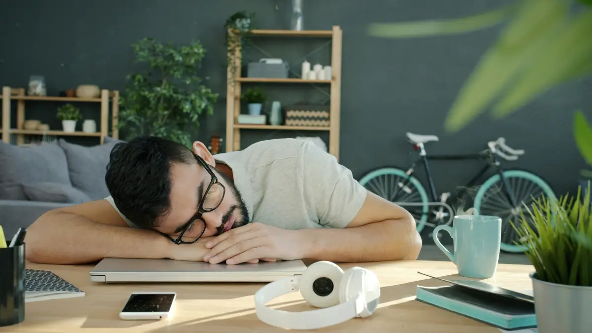 Un ragazzo in smart working si addormenta sul laptop
